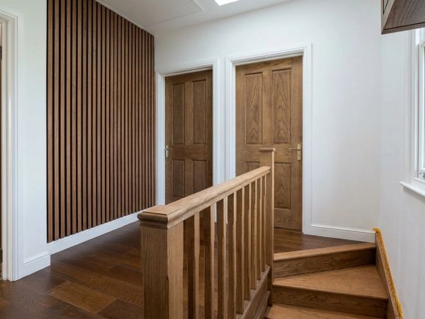 Modern hallway with wooden doors and staircase.