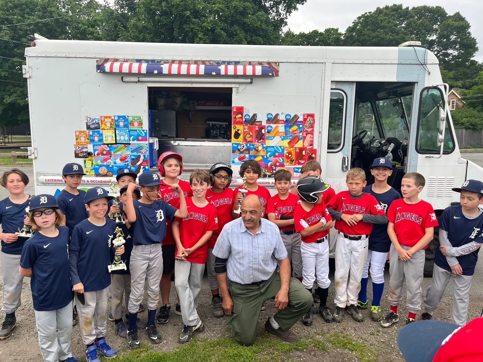 a group of children and adults standing in front of a food truck