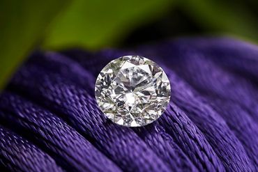 A diamond on a purple textured surface.