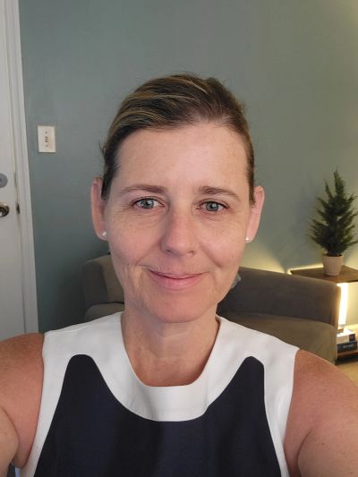 Woman smiling in a cozy living room.