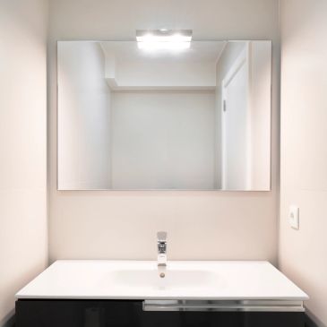 Minimalist bathroom sink with mirror and light.