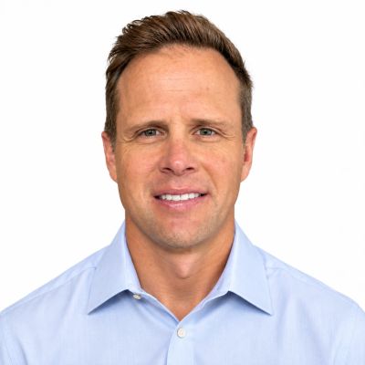 Portrait of a man in a blue shirt smiling.