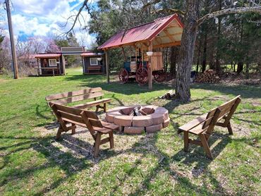 Rustic fire ring with benches and an old chuck wagon.