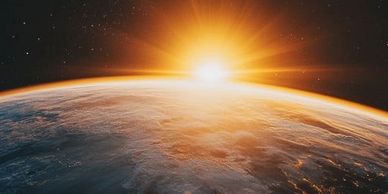 Sunrise over Earth from space with glowing horizon and stars.