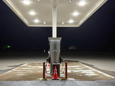 Empty gas pump at night under bright lights.