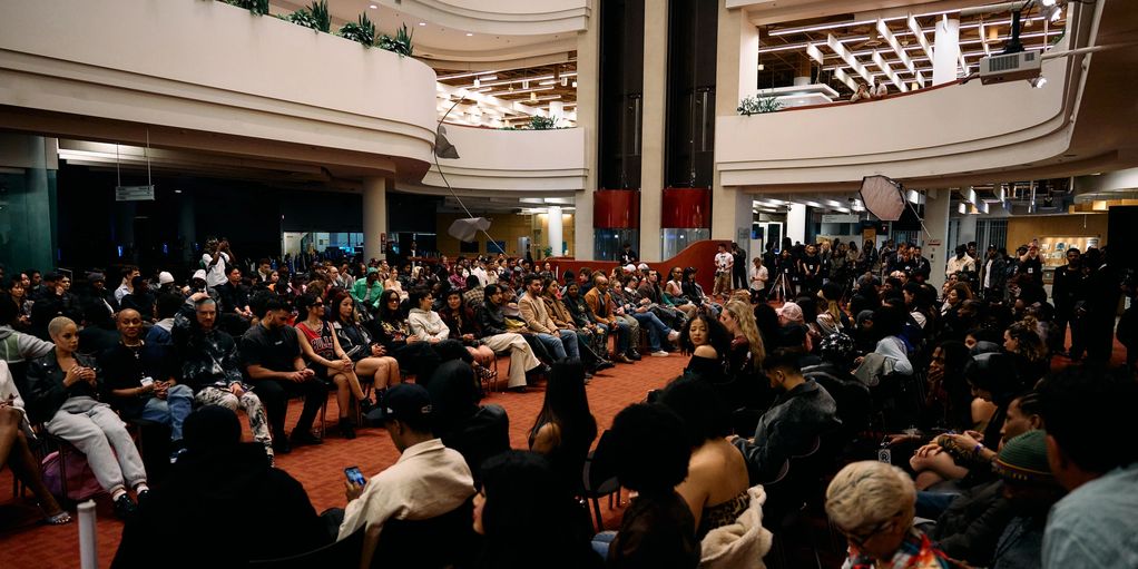 Large diverse audience seated in a modern indoor venue for an event.