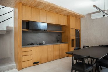 Modern kitchen with wooden cabinets and black dining set.
