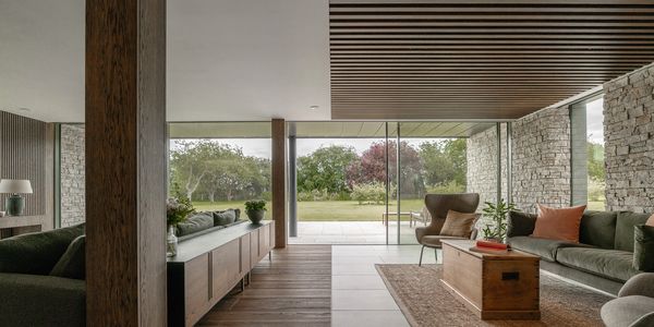 Raft ceiling and porcelain flooring, creating alounge area with a large TV , home cinema. Dark wood,