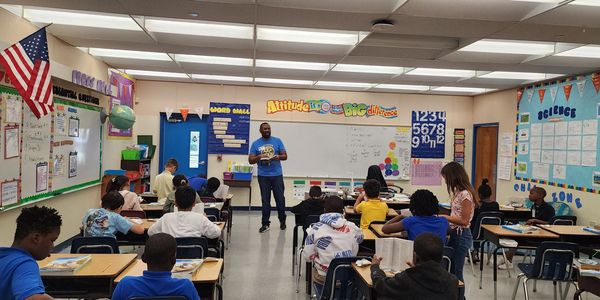 Sahim presenting dictionaries to class of 3rd graders at middle school in Pompano Beach
