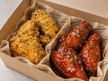 Two types of fried chicken wings in a box.