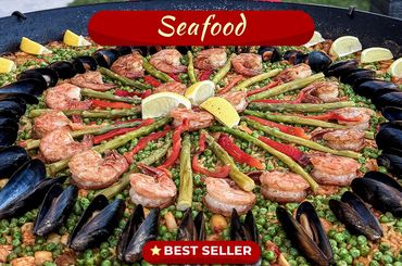 A colorful seafood paella with shrimp, mussels, asparagus, and lemon wedges.