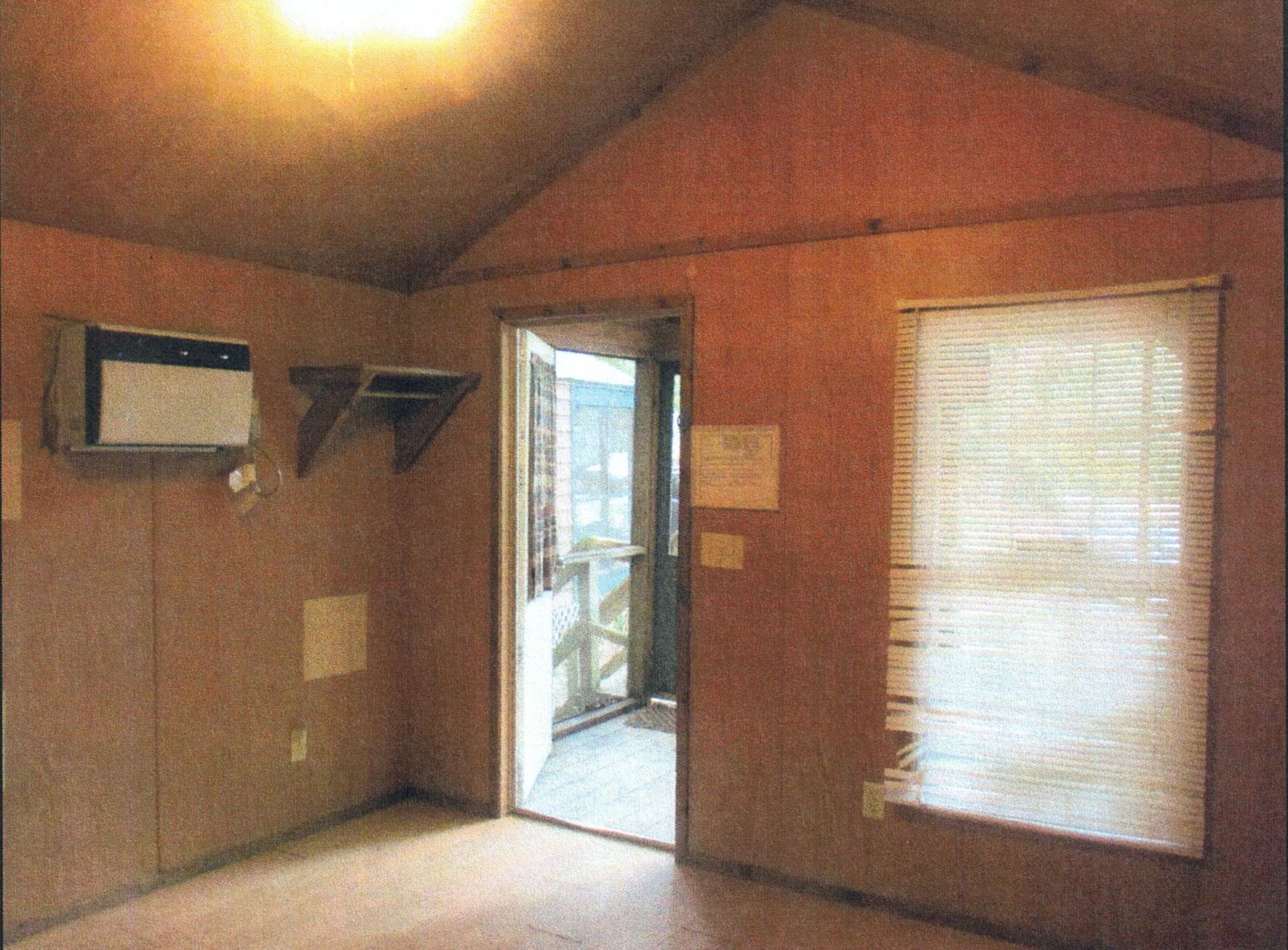 Inside of a cozy cabin rental at Hanna Park showing air conditioner, front door, and window