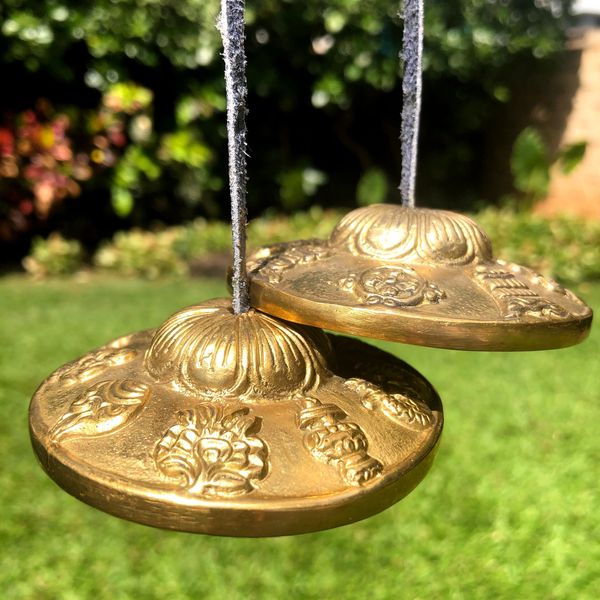 A Tingsha bell is ringing on the lawn at a sound bath session in Honolulu.