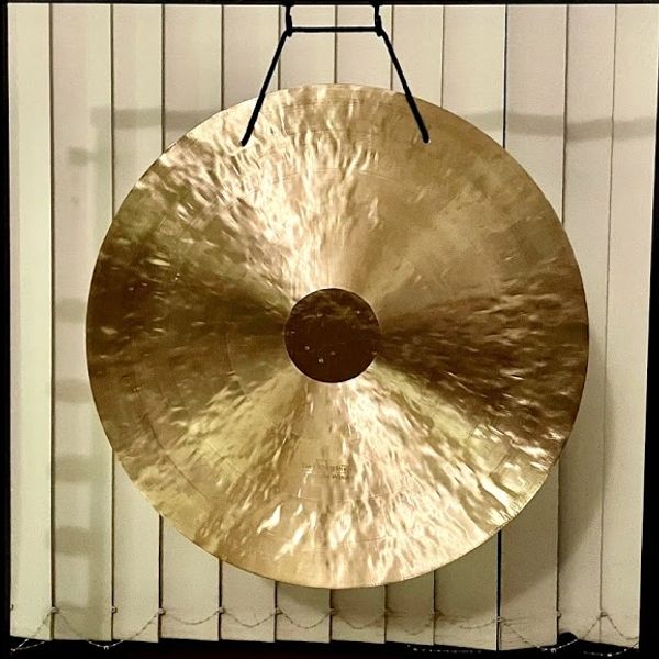 a wind gong with a stand at a sound healing session in Honolulu.