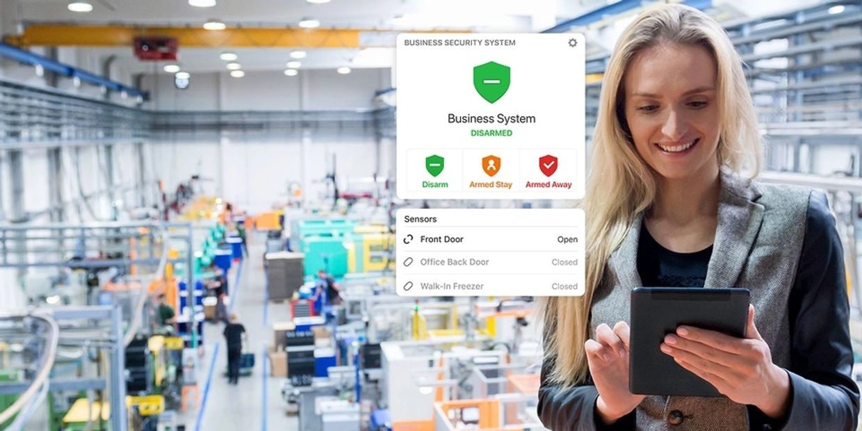 Business Operations Manager using alarm.com mobile app on her iPad in a factory setting