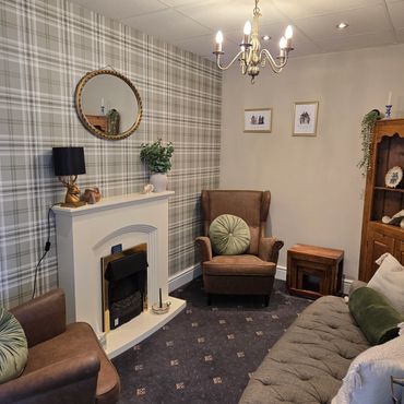 Cozy living room with plaid wallpaper and vintage furniture.