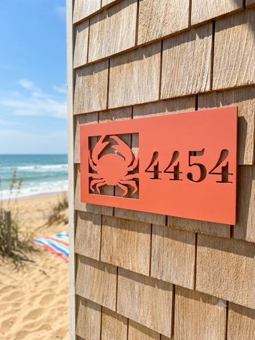 House number 4454 with a crab symbol on a beach house.