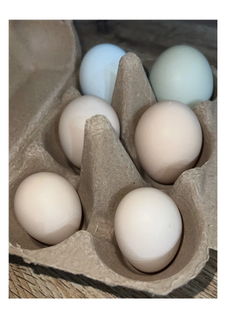 Half a dozen mixed sizes of eggs in a brown egg carton.