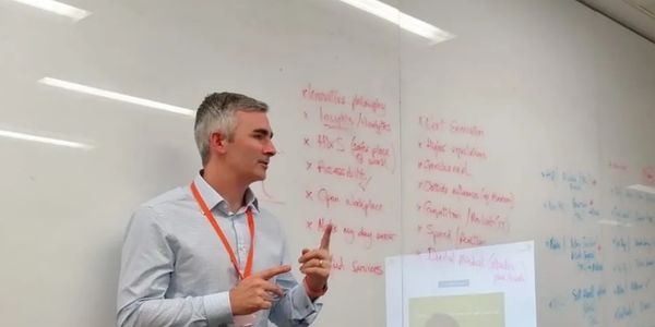 Geoffrey Doran giving a presentation in front of a whiteboard.