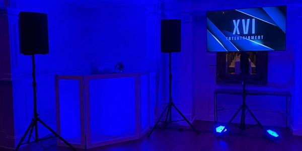 Blue-lit entertainment setup with speakers and a screen.