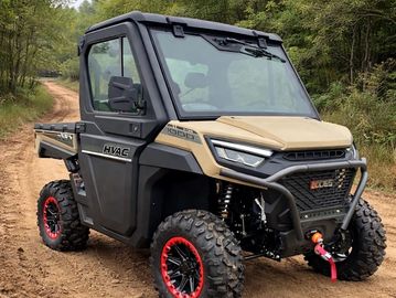 A rugged off-road utility vehicle on a dirt path with heavy tires and a winch.