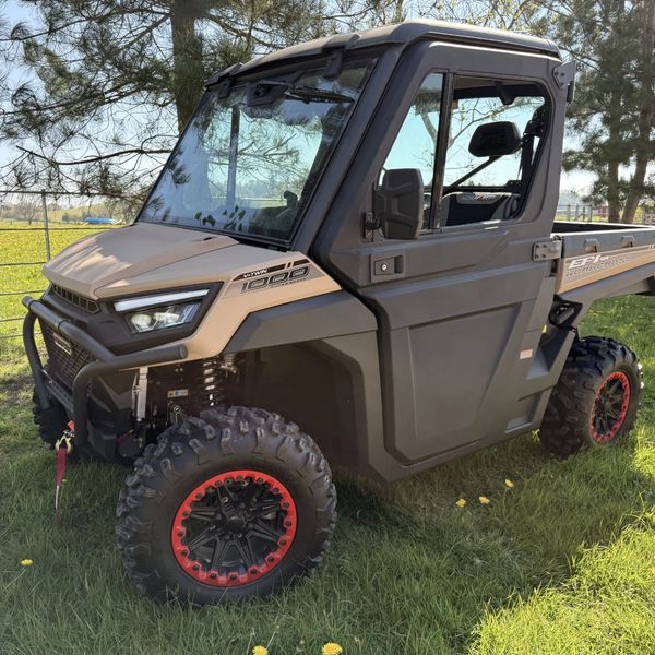 A rugged off-road utility vehicle with large tires and a protective cabin.