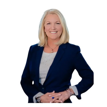 Smiling woman in a navy blazer with hands clasped.