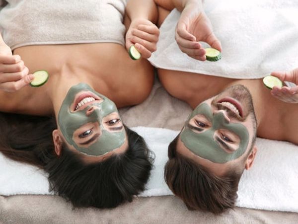 Man and woman applied face pack holding cucumber slices
