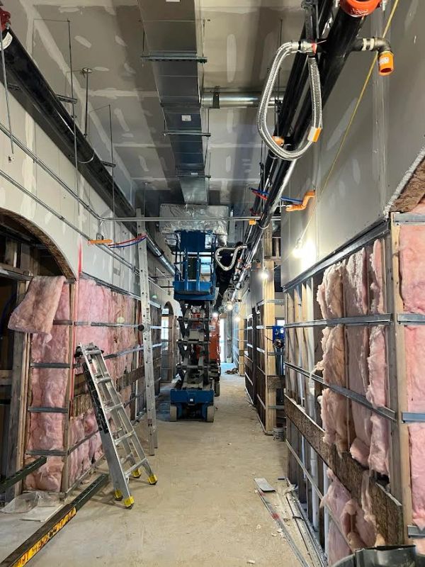 Construction site hallway with insulation and scaffolding.