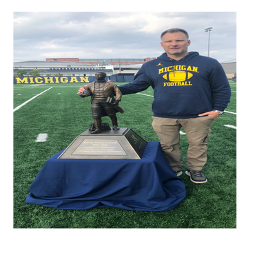 Andy Johnson delivering the George Jewett rivalry trophy to Schembechler Hall