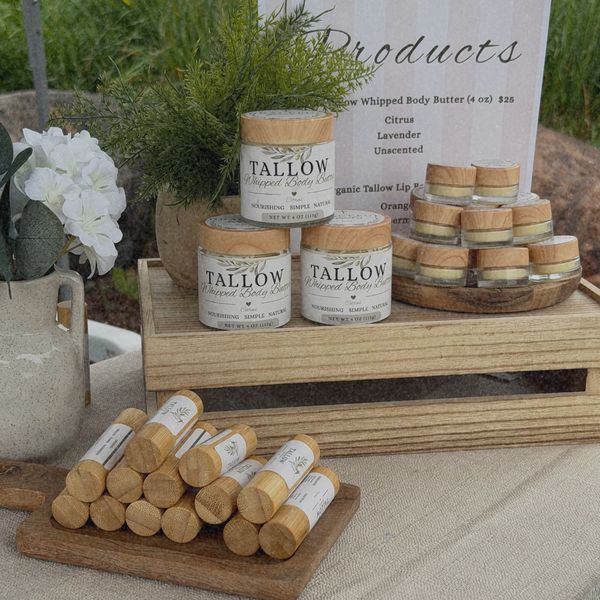 Display of natural skincare products including tallow body butter and lip balm.