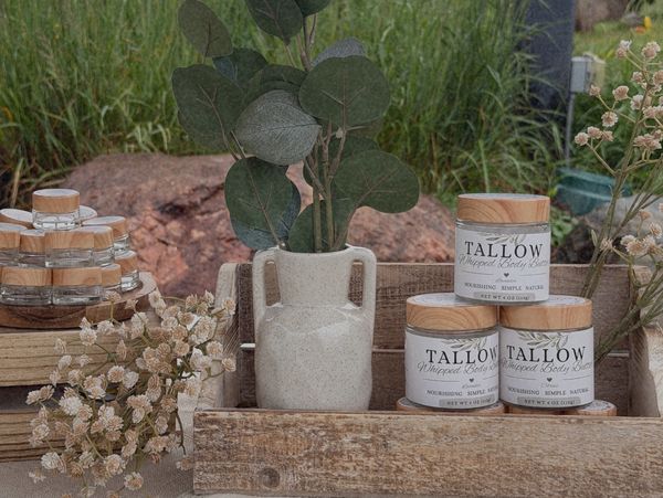 Natural skincare products displayed with potted plants and dried flowers.