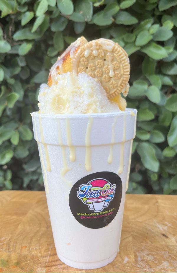 Iced Out sno-ball topped with a golden Oreo and drizzled with creamy sauce.