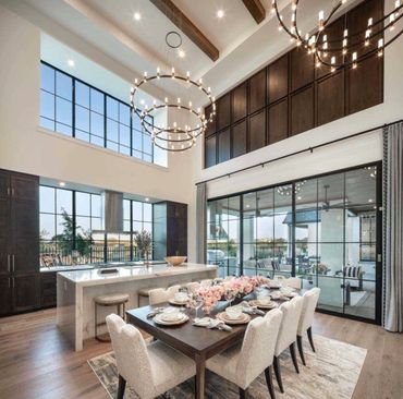 Elegant dining area with large windows and modern chandeliers.