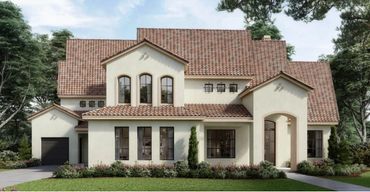 Elegant two-story house with tiled roof and lush landscaping in front.