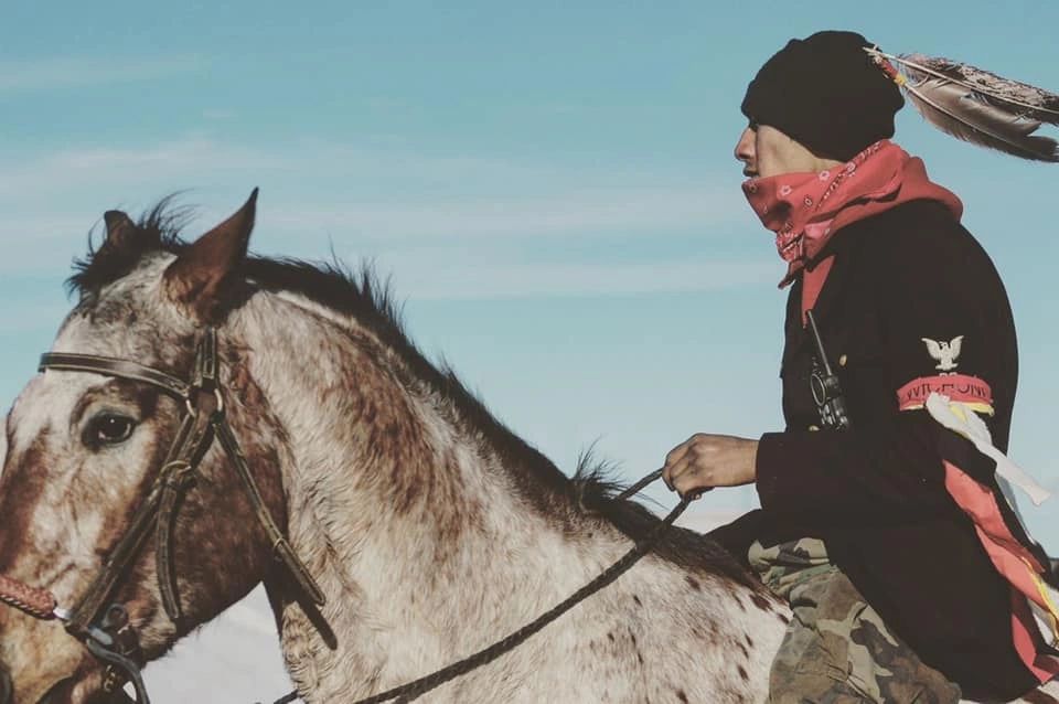 Lakota man riding horse at Standing Rock.