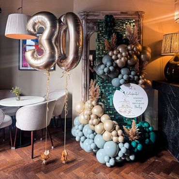 Elegant 30th birthday celebration setup with balloons and chic decor.