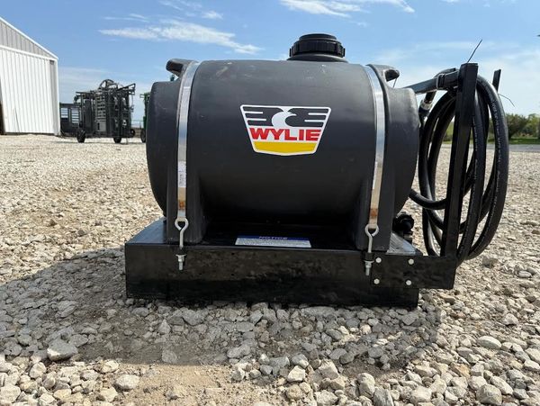 Black Wylie tank with hose on gravel.