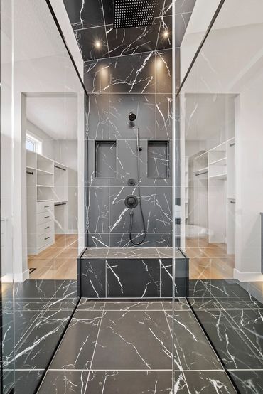 Custom glass walk in shower with black marble tile