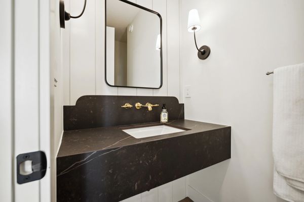 powder room with black marbl counter tops