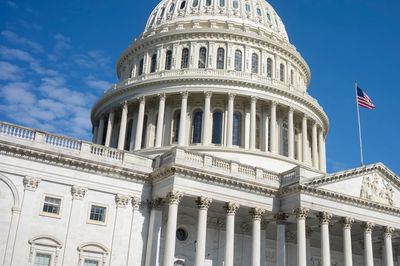Close-up of the U.S. Capitol dome with an American flag.