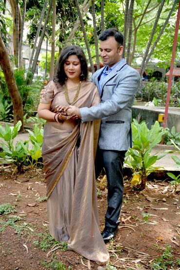 A couple in traditional attire posing in a garden.