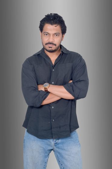 Man with crossed arms wearing a black shirt and blue jeans.