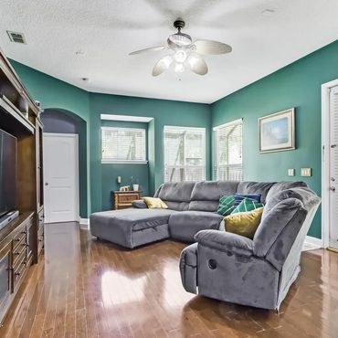 Cozy living room with teal walls, gray sectional sofa, and wooden entertainment center.