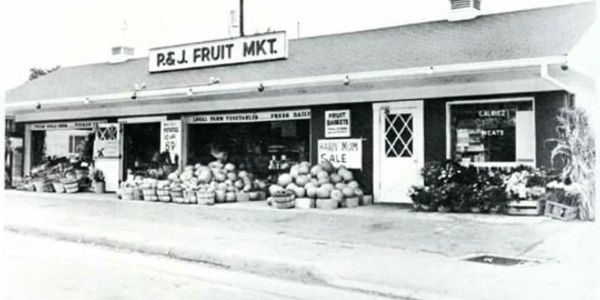 Black and white photo of P.& J. Fruit Market with pumpkins.