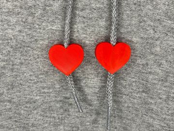 Red heart charms on sweatshirt drawstring.