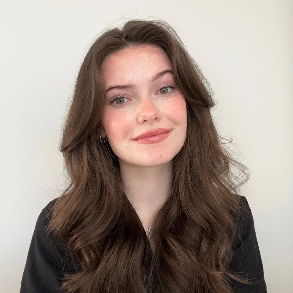 Young woman with long brown hair smiling.