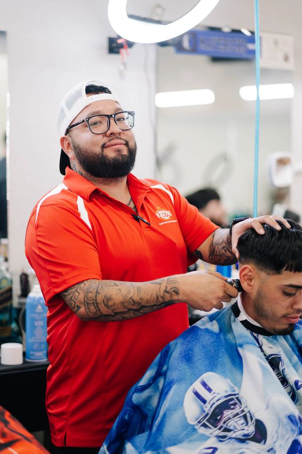 Barber School student confidently cutting a client’s hair independently.