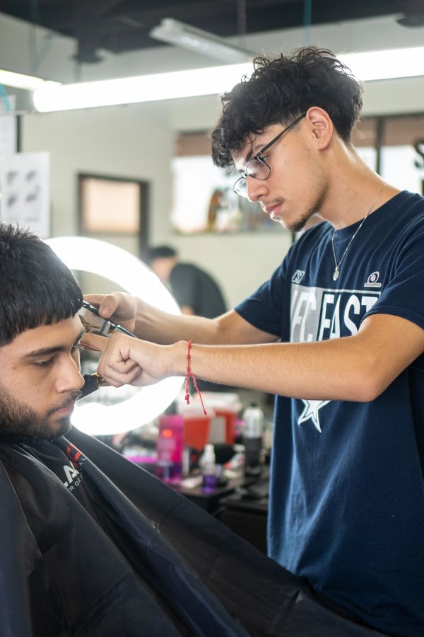 Fade Fellas Barber School student focused and confidently cutting a client’s hair.