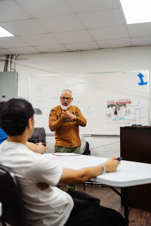 Fade Fellas Barber School instructor leading a classroom session on barbering techniques.